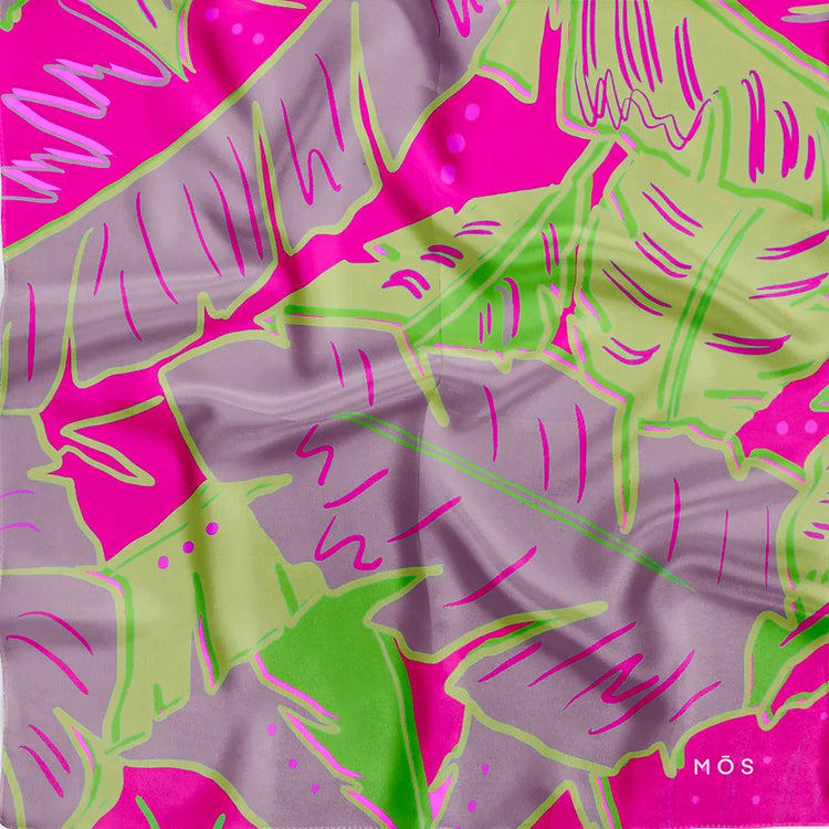 MŌS luxury bandana with bold tropical leaf print in purple and fuchsia and lime green, crafted in soft fabric with natural folds and logo detail.